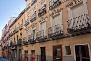 マドリードにあるLoft de lujo a pasos del pradoの通りに面したバルコニーと窓のある建物