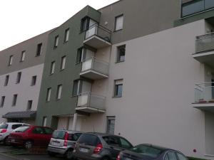 un grupo de coches estacionados frente a un edificio en Pacéenne, en Pacé