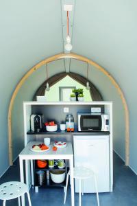 a small kitchen with a table and a microwave at Camping Fontana delle Rose in Mattinata