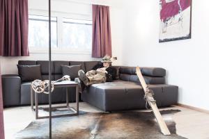 a man sitting on a couch in a living room at Schweiger in Sankt Anton am Arlberg