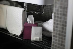 a bathroom counter with towels and a bottle of soap at Hotel Palazzo Grillo in Genova