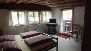 Schlafzimmer mit einem Bett, einem Schreibtisch und Fenstern in der Unterkunft Gästehaus Gerlinger in Rothenburg ob der Tauber