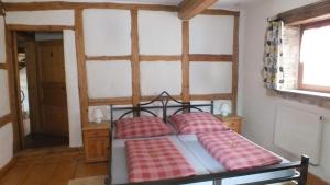 Schlafzimmer mit einem Bett mit roten und weißen Kissen in der Unterkunft Gästehaus Gerlinger in Rothenburg ob der Tauber