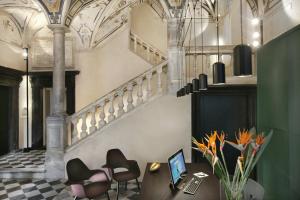 Habitación con mesa con sillas y ordenador portátil. en Hotel Palazzo Grillo en Génova