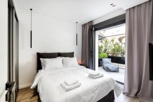 a bedroom with a large white bed and a balcony at Downtown Boutique Apartments in Athens