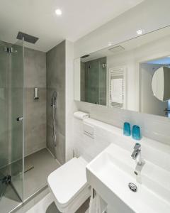 uma casa de banho com um chuveiro, um lavatório e um espelho. em Hotel Restaurant Goldener Engel em Heppenheim an der Bergstrasse