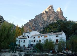 una casa bianca di fronte a una montagna di Alojamiento Rural El Molino De La Cerrada a Castril