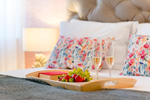 - un plateau de fruits et des verres à vin sur le lit dans l'établissement Deluxe Rooms Tramonto, à Split