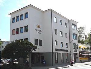 a white building with people standing in front of it at Hotel Storchen in Ravensburg