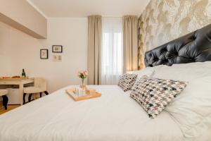 スプリトにあるDeluxe Rooms Tramontoのベッドルーム(白いベッド、黒い革のヘッドボード付)