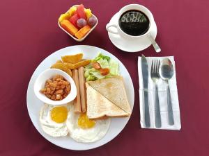 a plate of breakfast food with eggs toast and coffee at Prima Hotel Melaka in Malacca