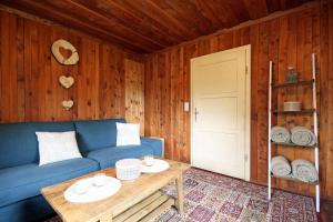 Una sala de estar con un sofá azul y una mesa. en Almliesl EBEN-588, en Ebene Reichenau 10 fotos más