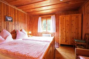 ein Schlafzimmer mit einem Bett in einem Holzzimmer in der Unterkunft Almliesl EBEN-588 in Ebene Reichenau