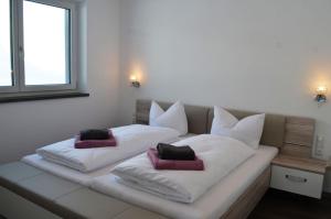 białe łóżko z dwoma poduszkami w obiekcie Zugspitzappartements w mieście Ehrwald