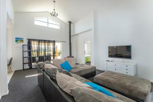 a living room with two couches and a tv at Hills Vista Lodge in Matamata