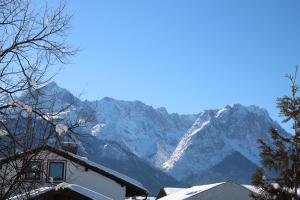 una montaña cubierta de nieve en la distancia con una casa en Alpen - Apartments II, en Garmisch-Partenkirchen 3 fotos más