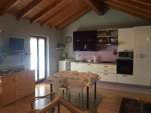 a kitchen with a table and a kitchen with white cabinets at Casetta dei Lupi in Miazzina