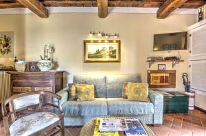 salon z niebieską kanapą i stołem w obiekcie Casa della Nonna A w mieście Gaiole in Chianti