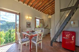 uma cozinha e sala de jantar com mesa e cadeiras em Casa della Nonna C em Gaiole in Chianti