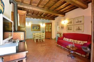 un salon avec un canapé rouge et une table dans l'établissement Il Portico, à Gaiole in Chianti