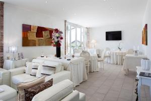 a dining room with white tables and white chairs at Locanda San Giorgio in Neviglie