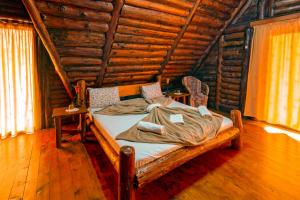 a bedroom with a bed in a log cabin at Raiul de pe Rau in Moroeni