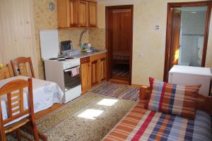 a kitchen with a couch and a stove top oven at Apartmani U Borovoj Šumi in Zlatibor