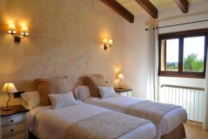 two beds in a room with two lamps on the wall at 065 Finca Son Costa ETV4943 by Mallorca Charme in Búger +25 photos