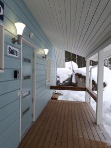 a front door of a house with snow on the porch at Vuokatti Slope Suite in Vuokatti