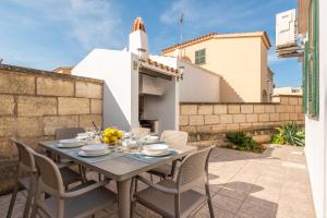 a table and chairs on the patio of a house at Villa Menurka I in Cala en Blanes