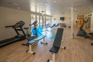 a gym with several treadmills and exercise bikes at Hotel Marina in Grenå
