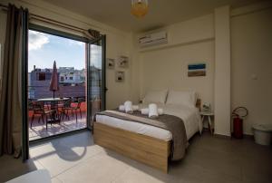 a bedroom with a bed and a balcony with a table at Central Stay Athens in Athens