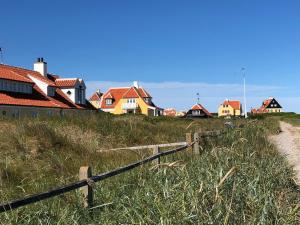 a group of houses on a hill with a fence at Annekset Skagen in Skagen