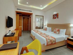 a hotel room with a large bed and a desk at Viola Beacon Resort, Lonavala in Lonavala