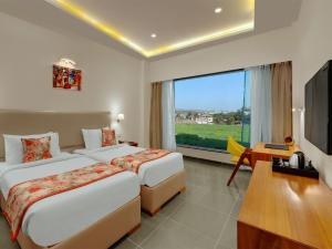 a hotel room with two beds and a large window at Viola Beacon Resort, Lonavala in Lonavala