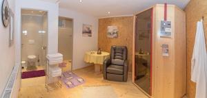 bagno con sedia, lavandino e doccia di Arenablick a Zell am Ziller