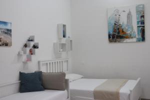 a white bedroom with a bed and a couch at La Casa dell'Emigrante in Gaeta