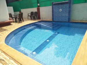 a large swimming pool with blue water in a building at GR Stays - 3Bhk Private Villa in Calangute with Private Jacuzzi Pool in Calangute
