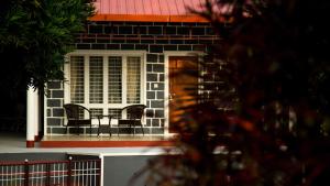 una casa con 2 sillas y una mesa en el porche en Siddhi Aloha en Madikeri