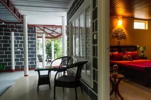 a room with a table and chairs and a bed at Siddhi Aloha in Madikeri