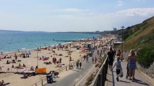 a crowd of people on a beach near the ocean at Beach Lodge in Bournemouth