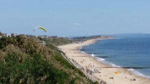 a beach with a kite flying over the ocean at Beach Lodge in Bournemouth