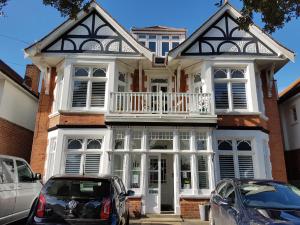 a house with two cars parked in front of it at Beach Lodge in Bournemouth