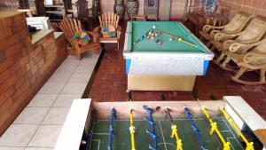a pool table with pool balls in a room with chairs at Hotel Cristo Rei 611 in São João del Rei