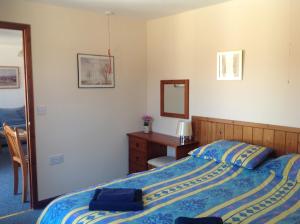 a bedroom with a bed and a desk and a mirror at Stable Cottages in Cowes
