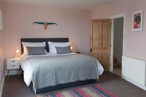 a bedroom with a large bed and a wooden door at The Salt House, Fore Street in Ilfracombe