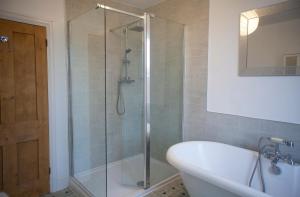 a bathroom with a shower with a tub and a sink at The Salt House, Fore Street in Ilfracombe +11 photos