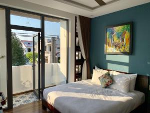 um quarto com uma cama e uma grande porta de vidro em La An Homestay em Hoi An