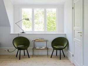 duas cadeiras verdes num quarto com uma janela em Hotel Stelor em Västergarn