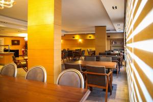 comedor con mesas y sillas de madera en New Gate Hotel, en Ankara